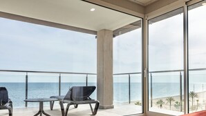 Varanda com vista para o mar, uma mesa e duas cadeiras.