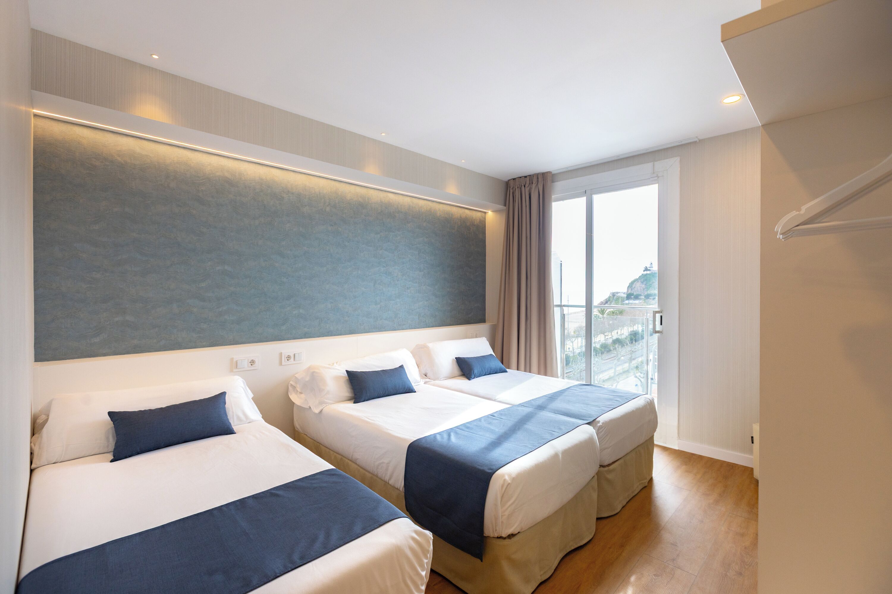 Habitación doble con cama supletoria, vistas al mar | Cofres nos quartos, escrivaninha, Wi-Fi de cortesia, roupa de cama