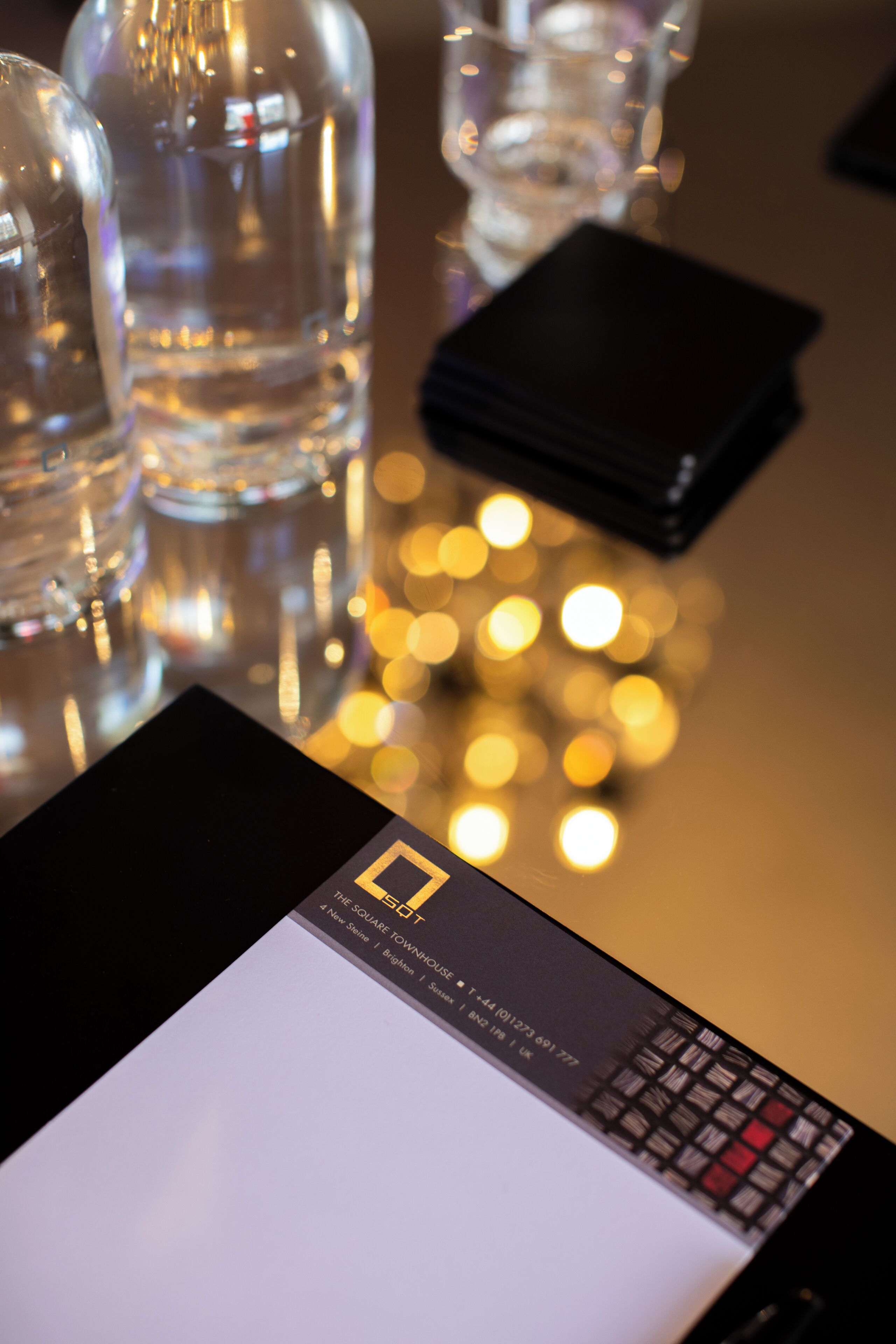 A table with a black wallet, clear glass bottles, and a card with text.