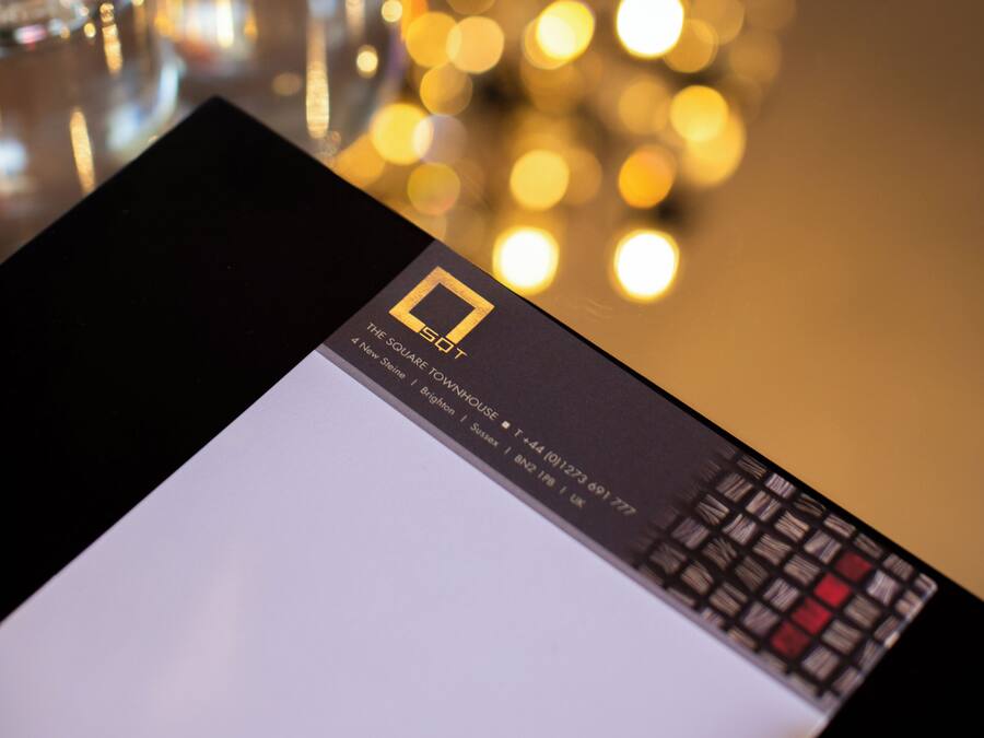 A table with a black wallet, clear glass bottles, and a card with text.