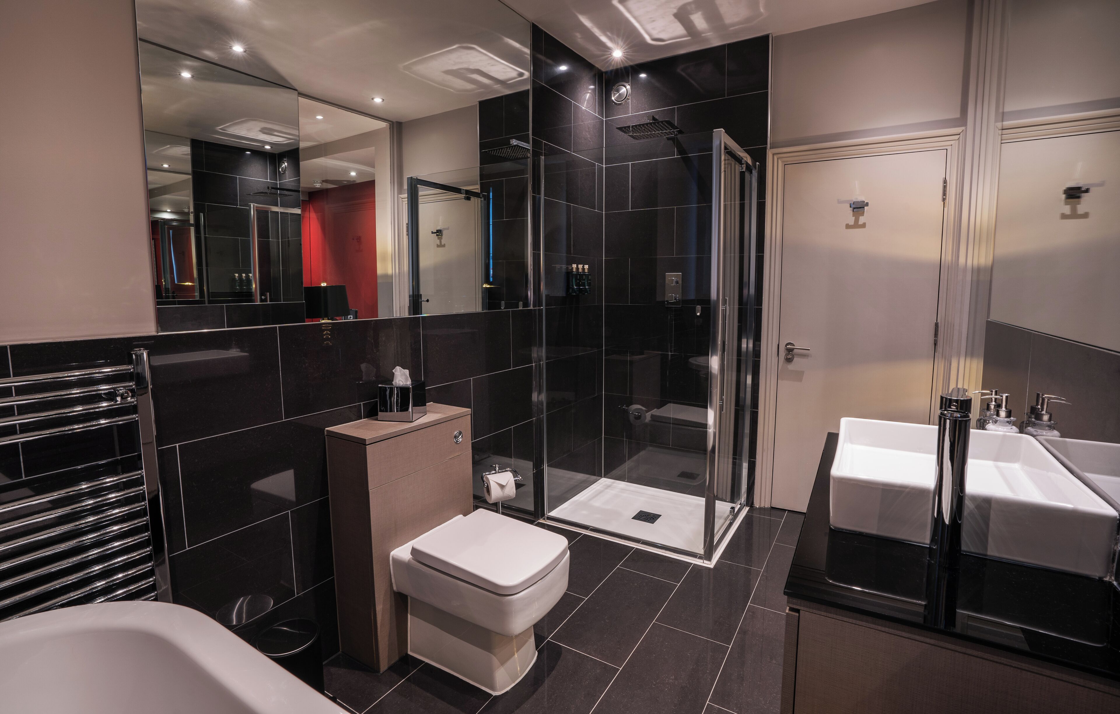 Un baño moderno con cabina de ducha de vidrio, inodoro separado y tocador doble.