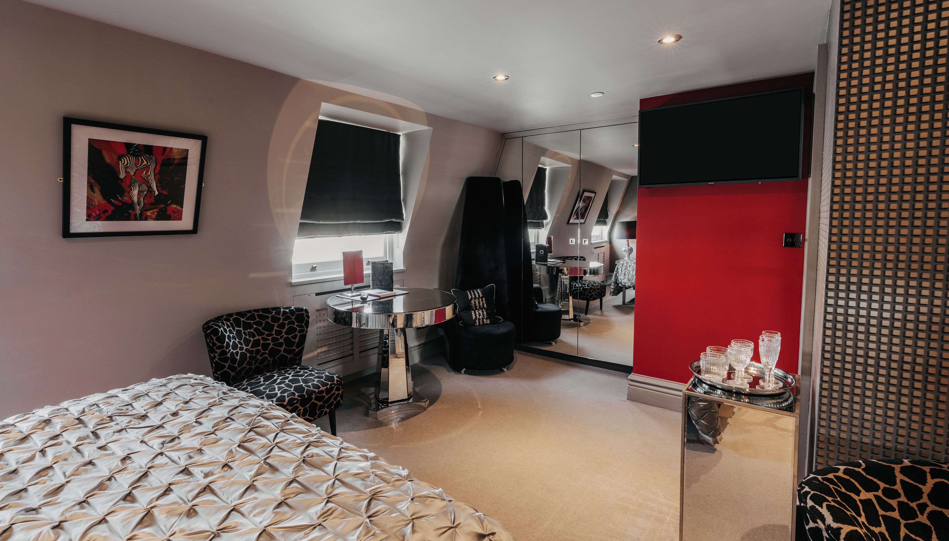 Un dormitorio moderno con cama, escritorio, silla y espejo.