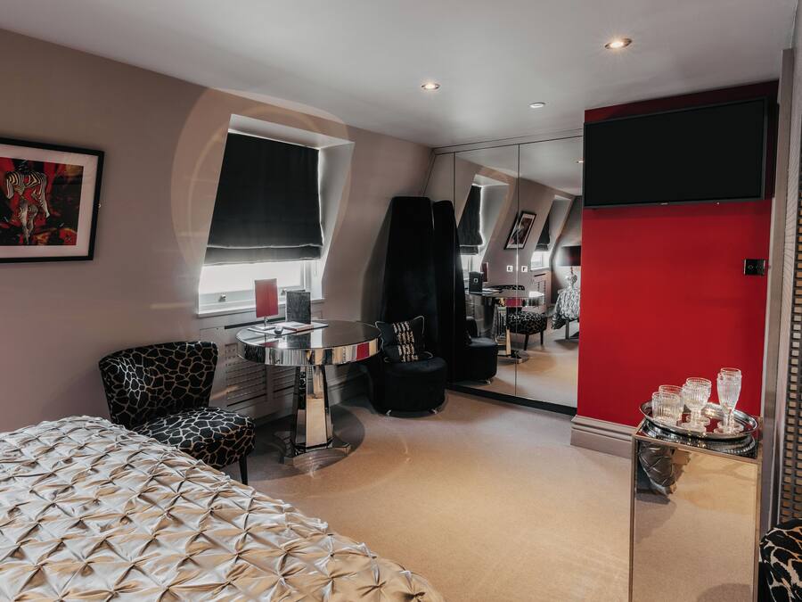 Un dormitorio moderno con cama, escritorio, silla y espejo.