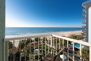 A balcony with a view of a beach and ocean.