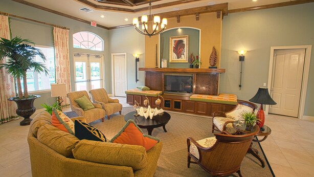 A spacious living room with a fireplace, comfortable seating, and a large television. - Coral Cay Resort by Sky Hotels & Resorts (Kissimmee)