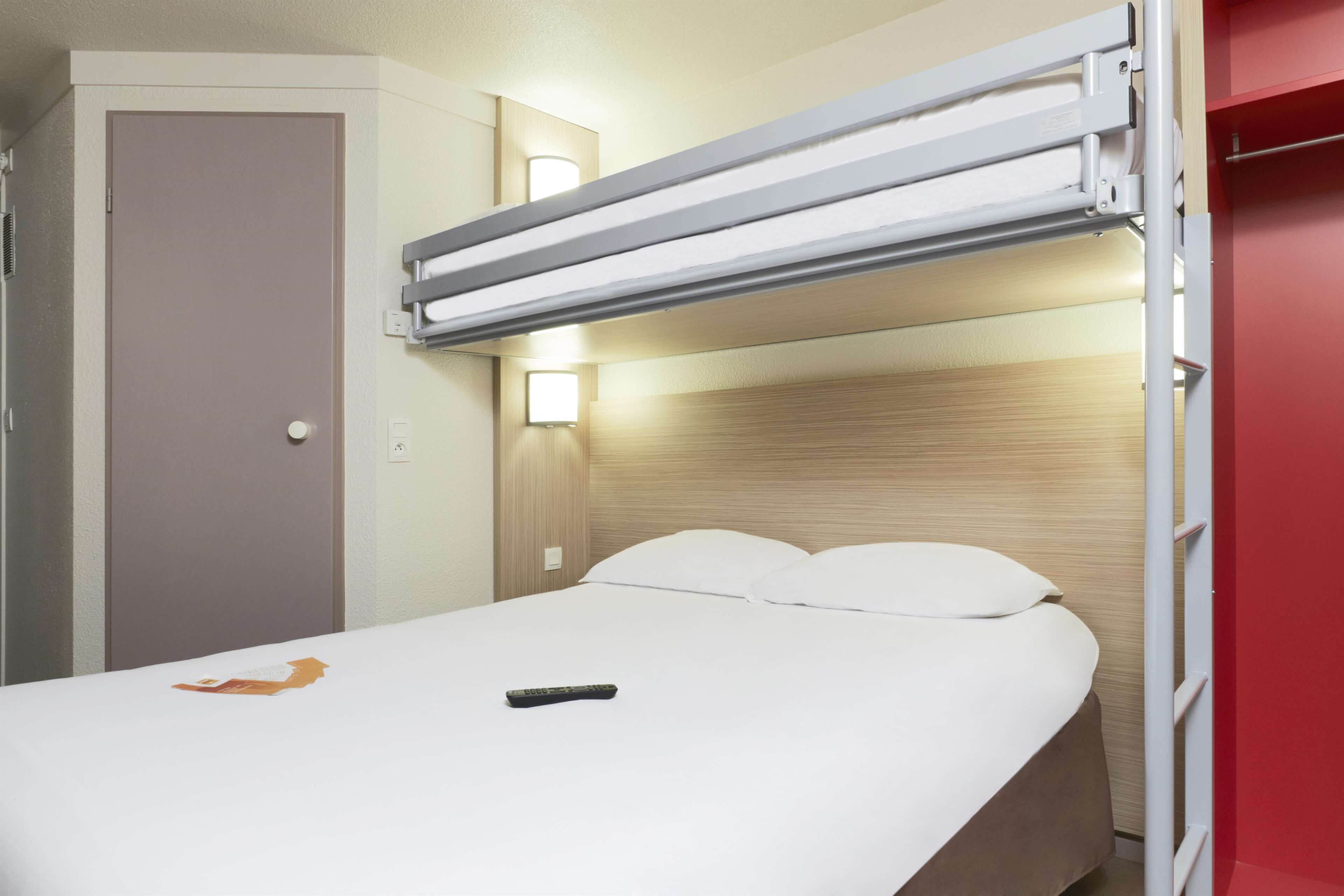 A single bed with a headboard, a bedside table, and a wall-mounted light fixture.