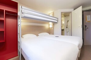 A hotel room with a bed, a red wardrobe, a bedside table, a nightstand, and a shower area. - Hotel Première Classe Chalon Sur Saone (Chalon-sur-Saone)