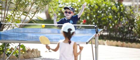 Una mesa de ping pong al aire libre con dos jugadores.