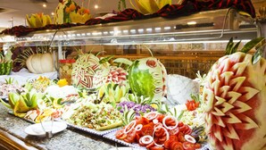 Un bufé con una variedad de alimentos, que incluyen frutas, verduras y ensaladas.