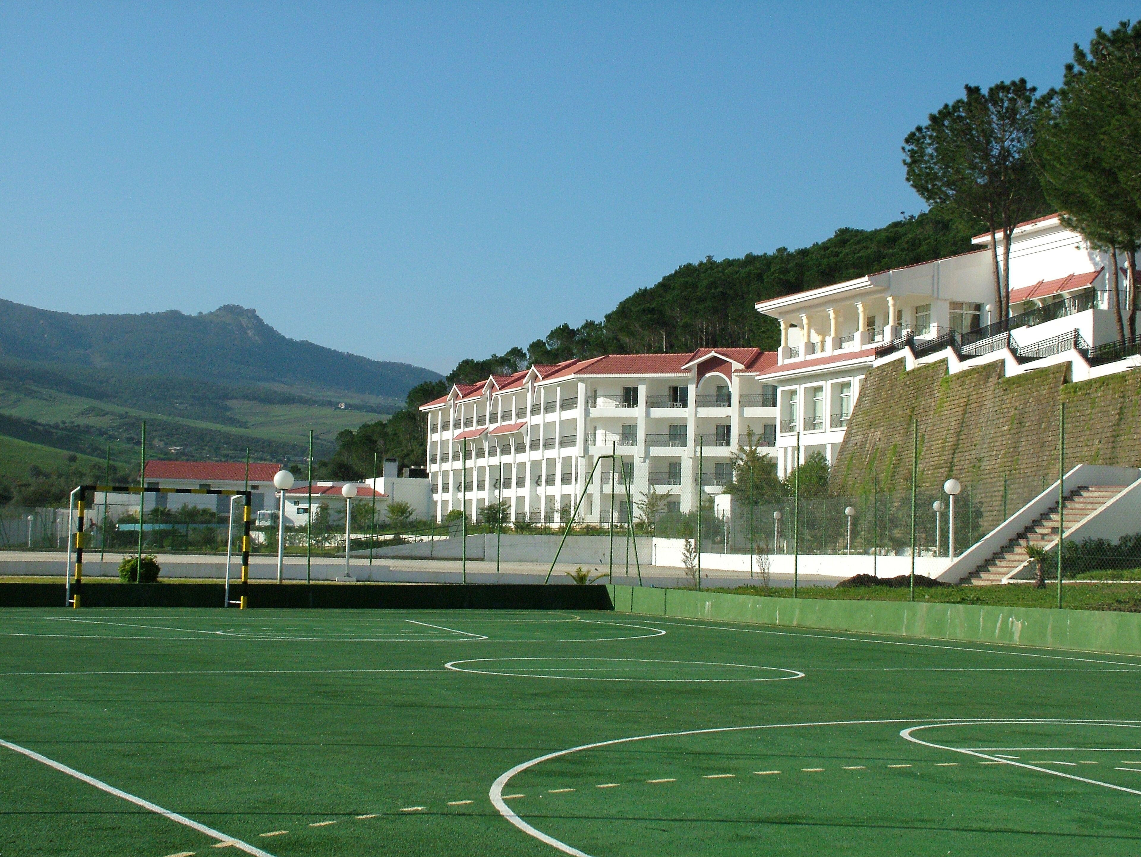 Ein Sportplatz mit einem Gebäude im Hintergrund.