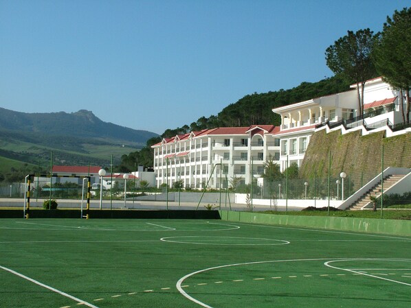 Un campo deportivo con un edificio al fondo.