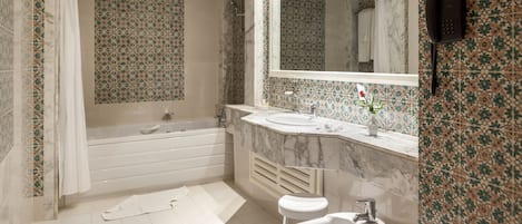 A bathroom with a bathtub, a sink, and a mirror.