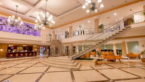 A spacious lobby with a grand staircase, a bar area, and multiple seating options. - Naama Bay Hotel & Resort (Sharm El Sheikh)