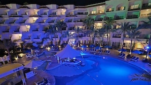 A hotel with multiple balconies, a swimming pool, and a spa area.