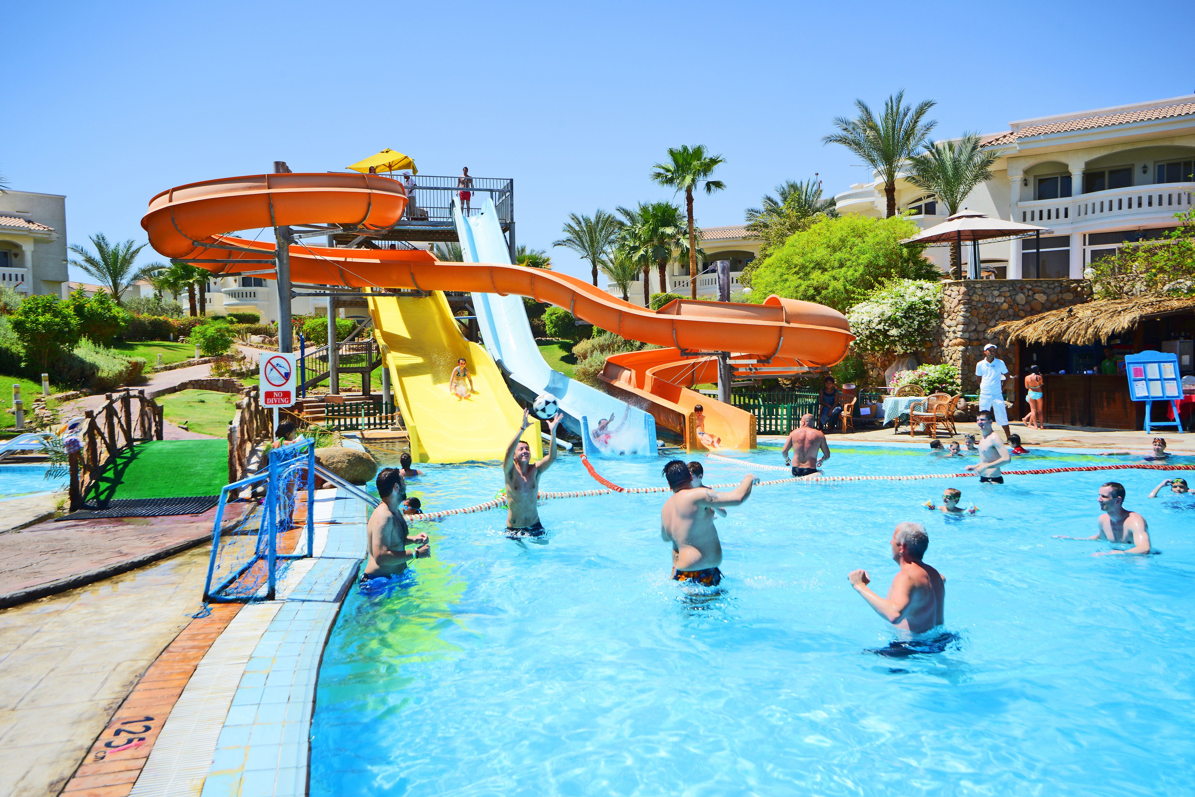 Parque acuático con múltiples toboganes y una piscina.