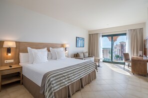 Relax in a spacious room with a large bed, sofa, and armchairs, plus a desk for work and a balcony with a view.