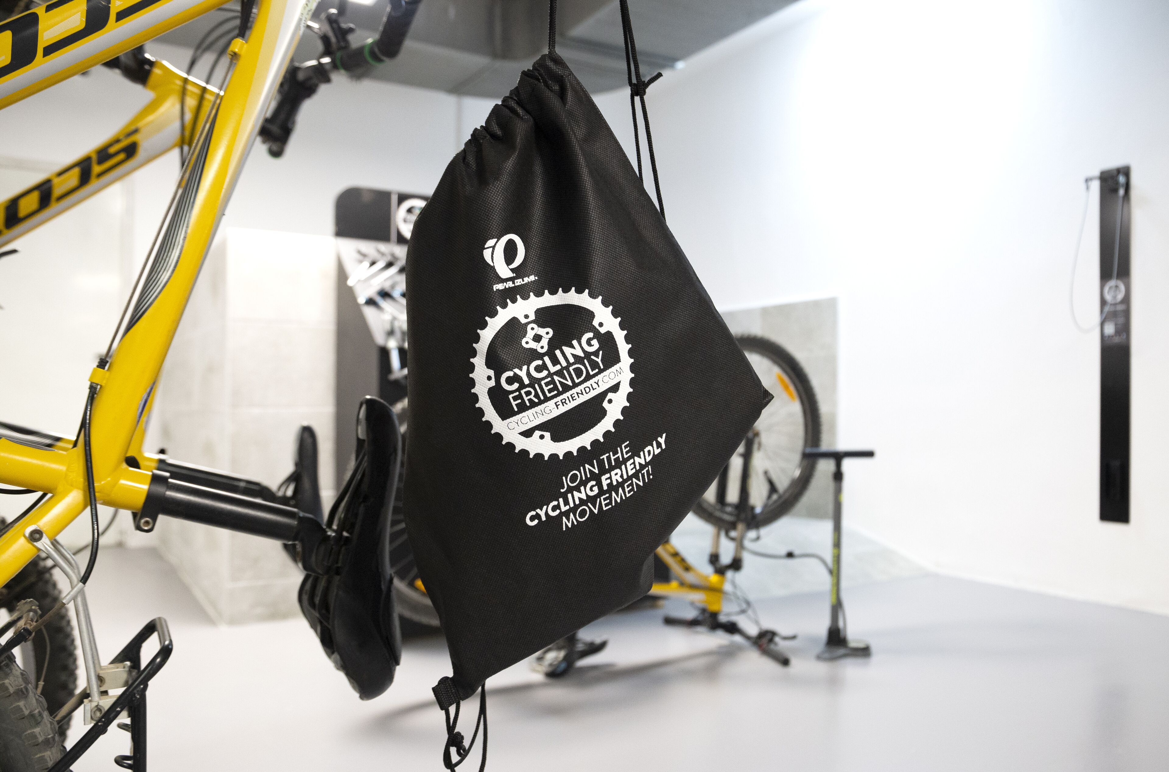 Ein gelbes Fahrrad mit einer schwarzen Tasche, die am Rahmen befestigt ist.