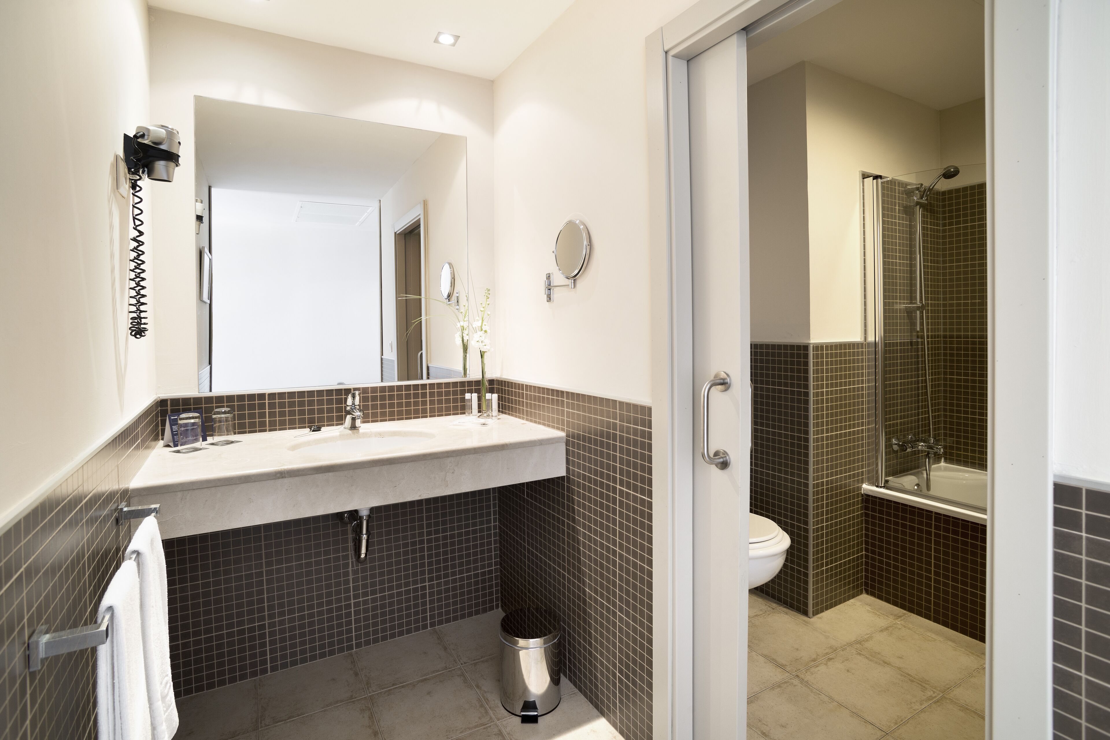 A bathroom with a sink, mirror, and toilet.