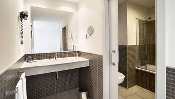 A bathroom with a sink, mirror, and toilet.