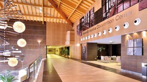 A spacious convention center with a high ceiling, modern lighting fixtures, and a central open area with seating. - Barceló Punta Umbria Beach Resort (Punta Umbría)