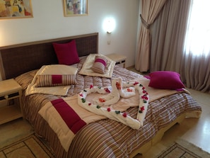 A neatly made bed with striped bedding, a headboard, and decorative pillows.