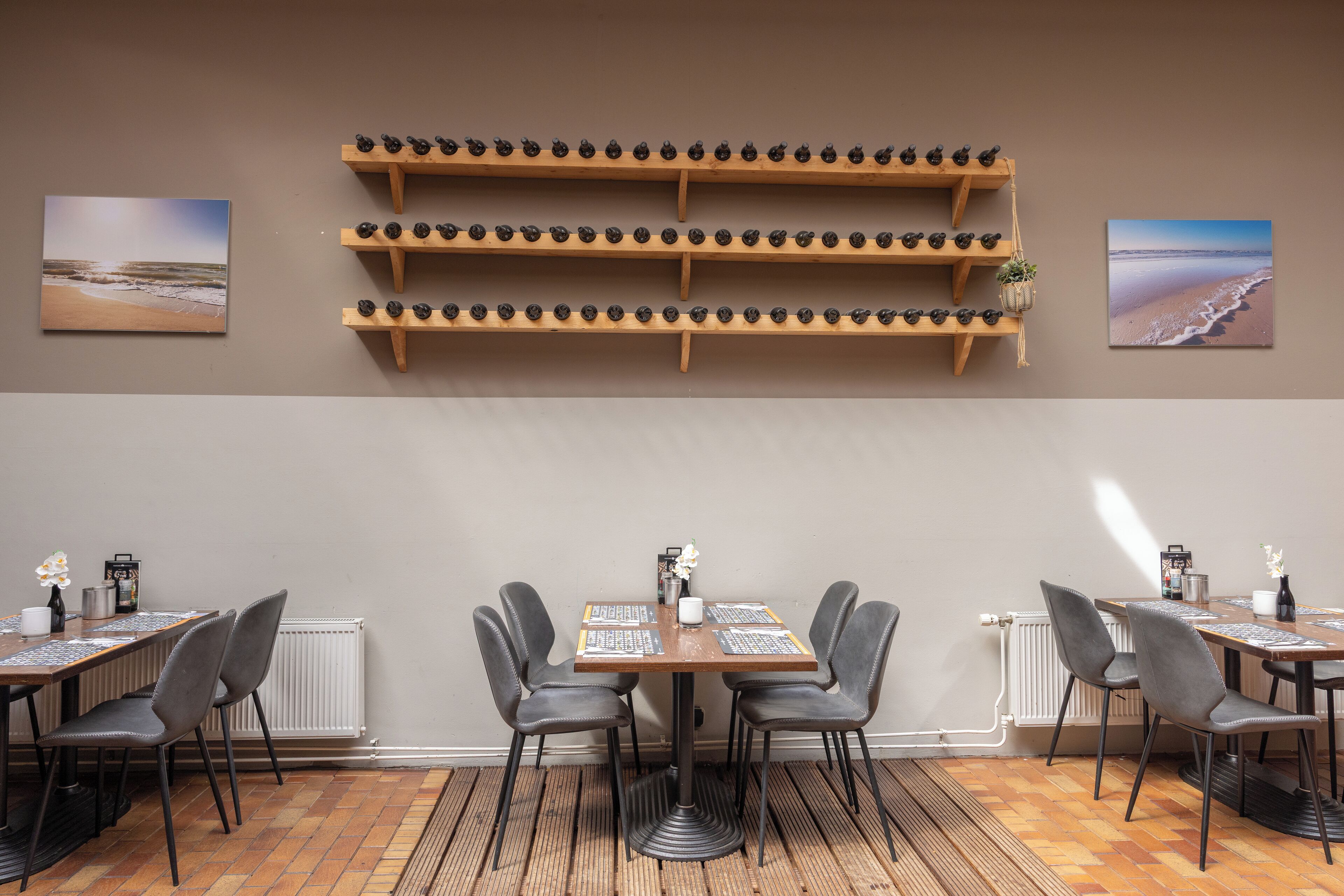 Un comedor con una mesa y sillas de madera, una estantería con adornos y dos cuadros en la pared.