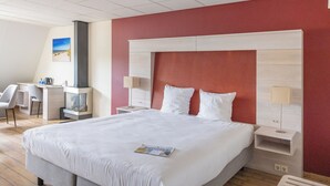 Une chambre d’hôtel avec un grand lit, un bureau et une chaise.