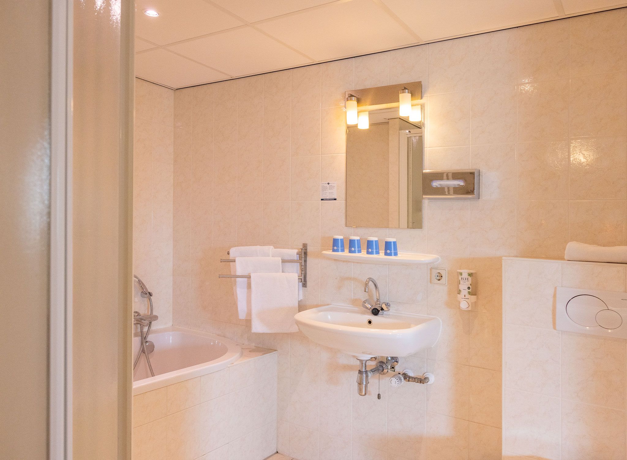 Ein modernes Badezimmer mit einer Badewanne, einem Waschbecken und einem Spiegel.