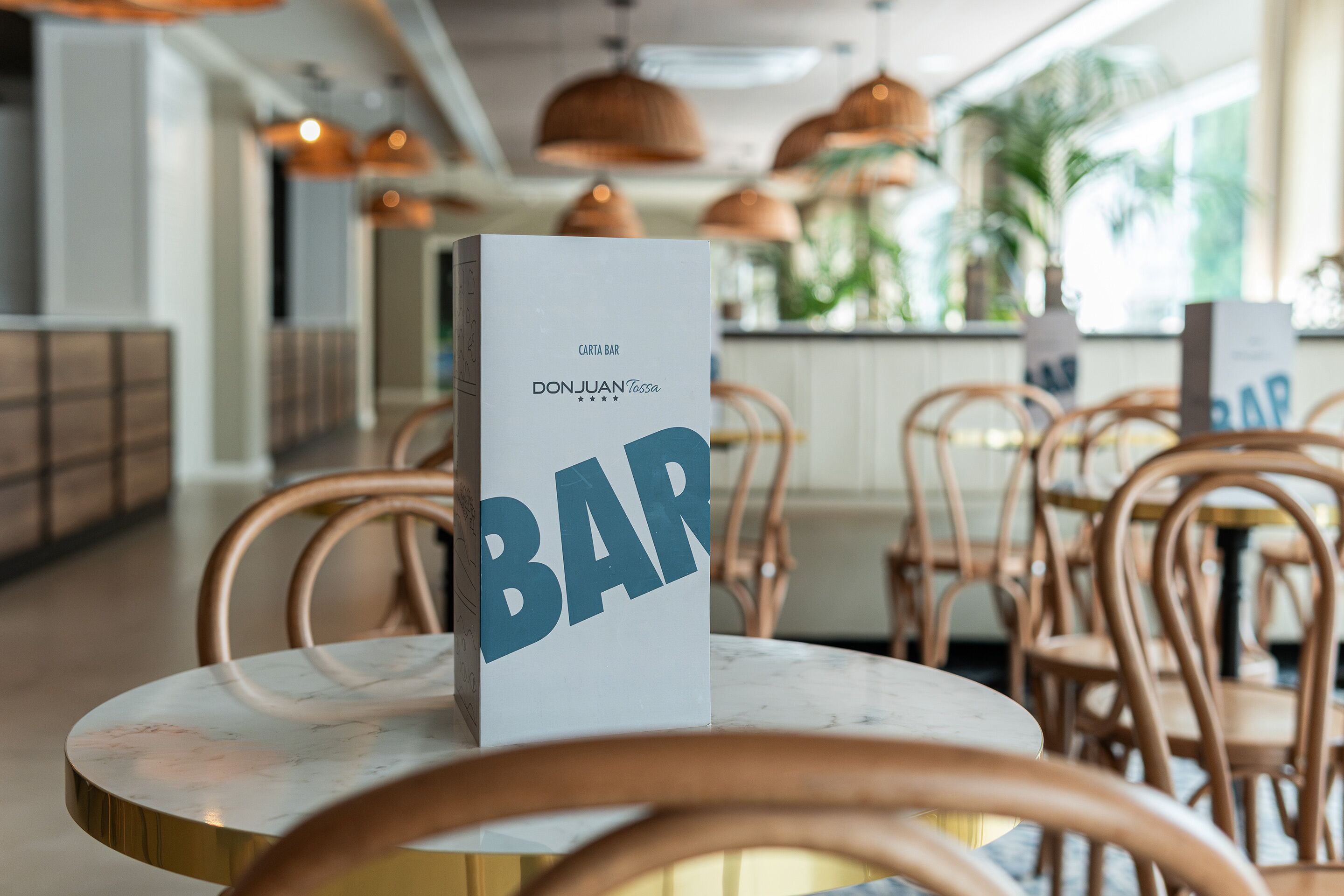 Een barbord met de naam 'DonJuan Tossa' in een restaurant.