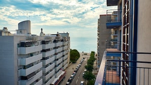 A multi-story building with balconies overlooking a street and a body of water. - Checkin Blanes (Blanes)