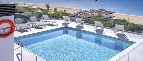Une piscine à débordement située sur le toit, offrant une vue dégagée sur la plage et l’océan.