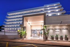 A modern hotel entrance with a clear sign reading 'HOTEL TROPIC PARK' and a series of potted plants at the entrance. - Hotel Tropic Park (Malgrat de Mar)