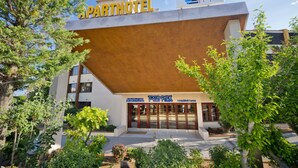 An apartment hotel with a modern design, a sign for Tossa Park, and a website URL. - Apart-hotel GHT Tossa Park (Tossa de Mar)