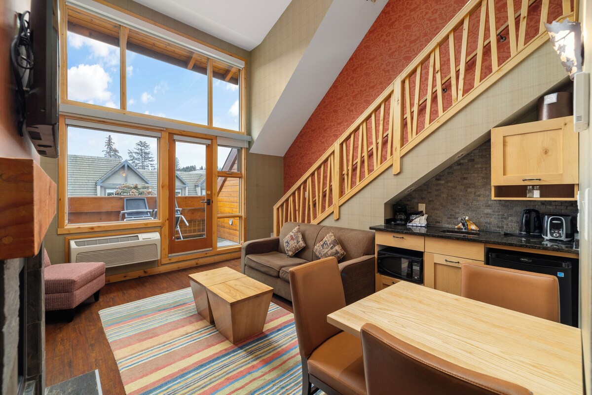 A modern interior with a sofa, dining table, and kitchen area.