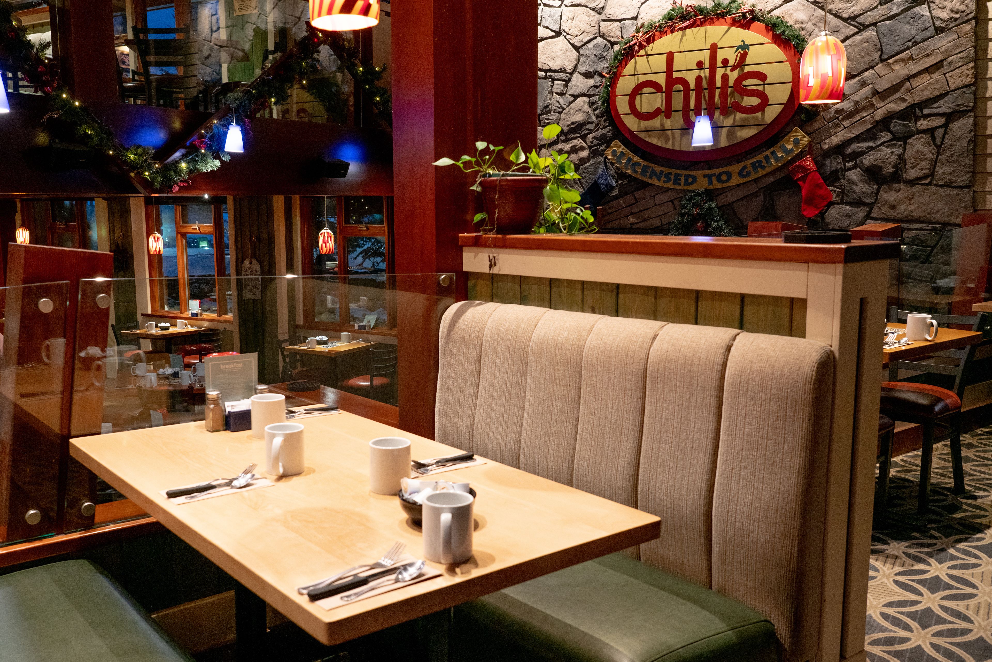 Un interior de restaurante con cabinas, una pared de piedra y un letrero que dice 'Chili's'.