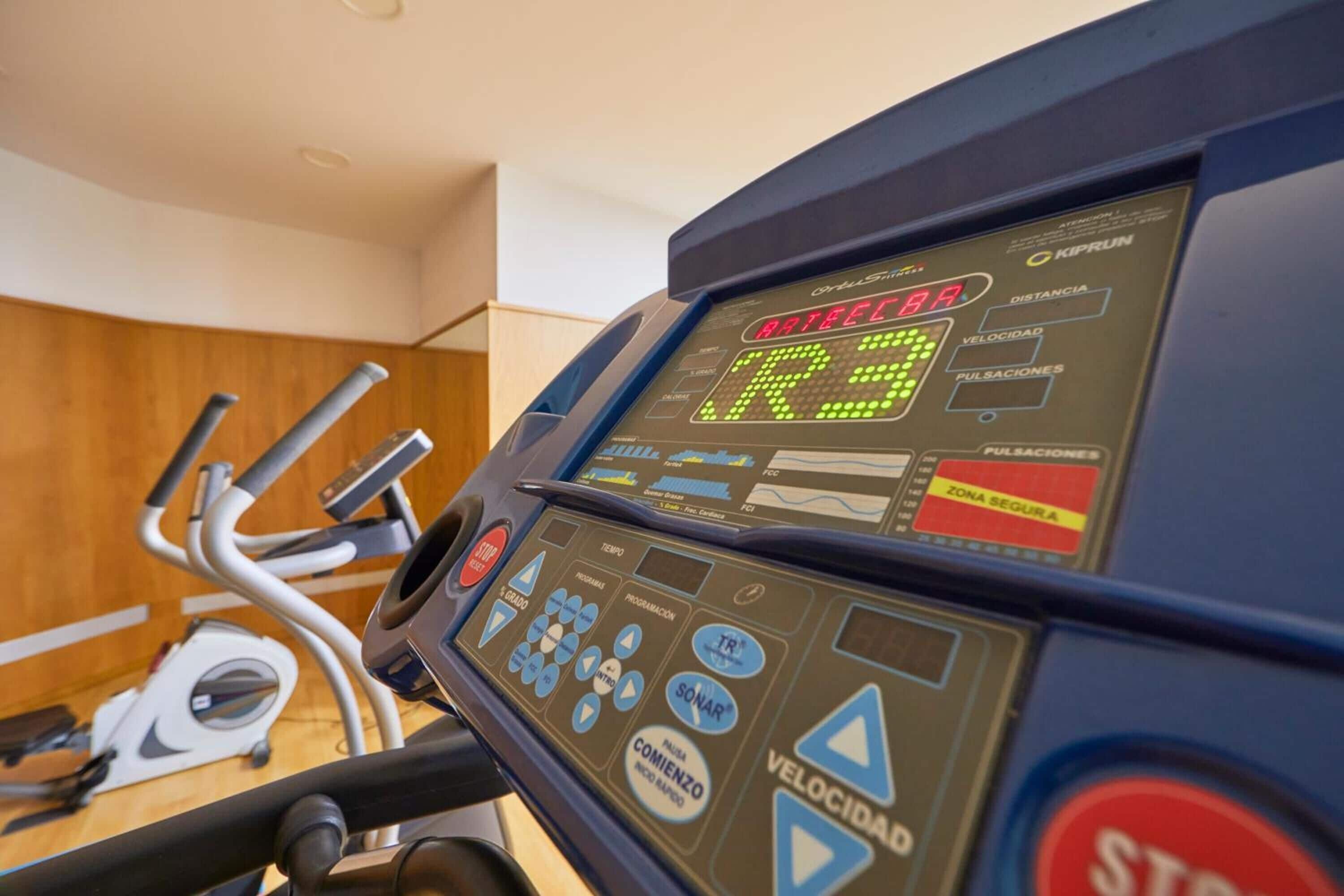 A treadmill control panel with various buttons and a digital display.