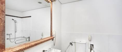 Un baño moderno con lavamanos, espejo y retrete.