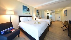 Una habitación de hotel con dos camas, un escritorio, una silla y un televisor.
