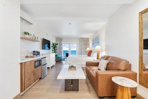 A modern apartment with a kitchen, dining area, and living room.