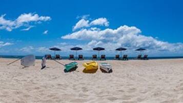 A beach with umbrellas and beach chairs.
