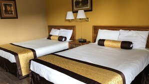 A hotel room with two beds, each with a white and brown bedspread, and a wall-mounted lamp. - Knights Inn Baker City (Baker City)