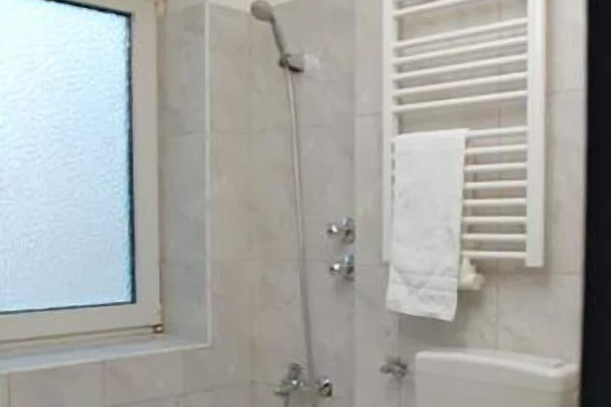 Une salle de bain avec une baignoire, des toilettes et une fenêtre.