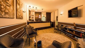 Een hotellobby met een receptiebalie, een zithoek en een modern interieur.