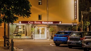 Een hotelentree met een bord waarop staat 'City Hotel Mercator'.