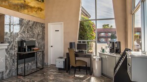 A modern kitchen with marble countertops, a coffee station, and a view of the outside. - Laurel Inn Motel (Salinas)