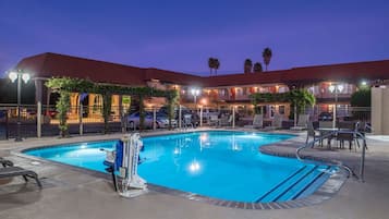 Relax by the pool surrounded by a deck with lounge chairs and a seating area.
