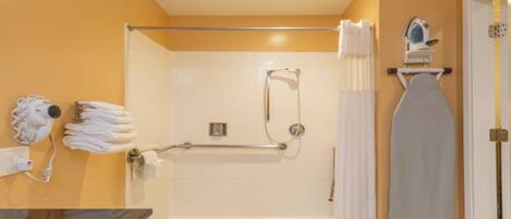 A bathroom with a shower, a towel rack, and a hairdryer.