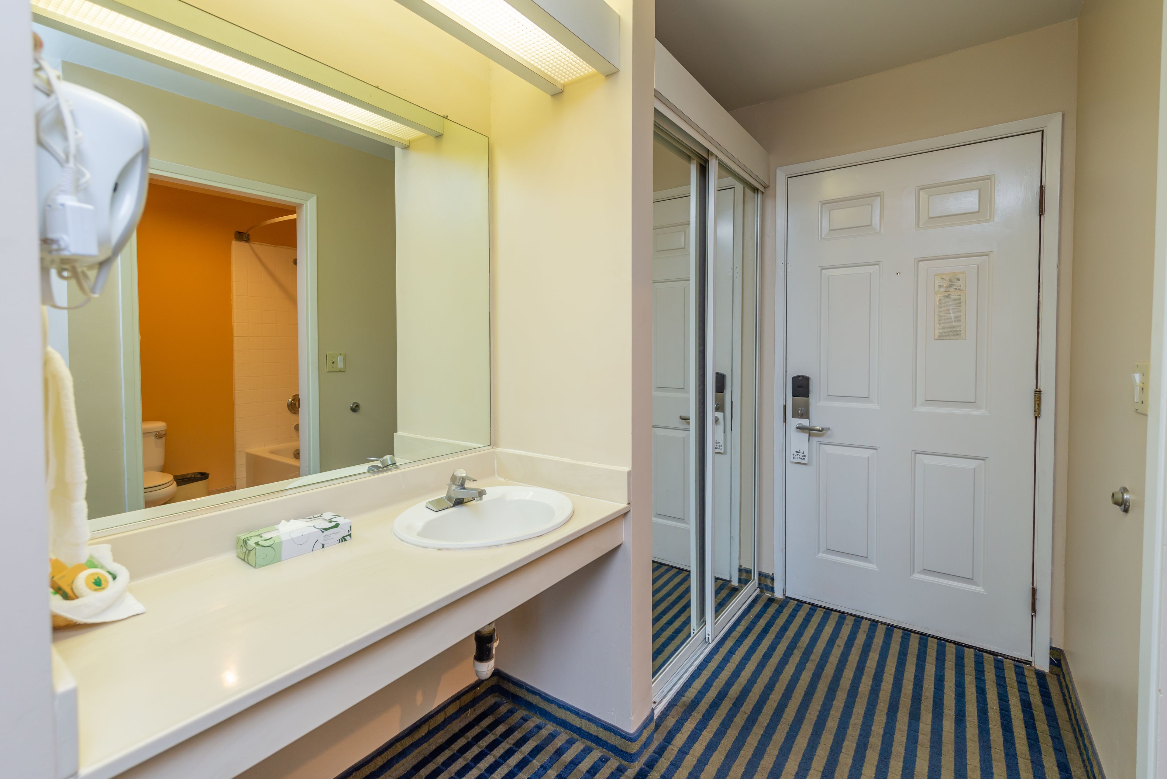 A bathroom with a white sink, a mirror, and a shower door.