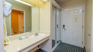 A bathroom with a white sink, a mirror, and a shower door.