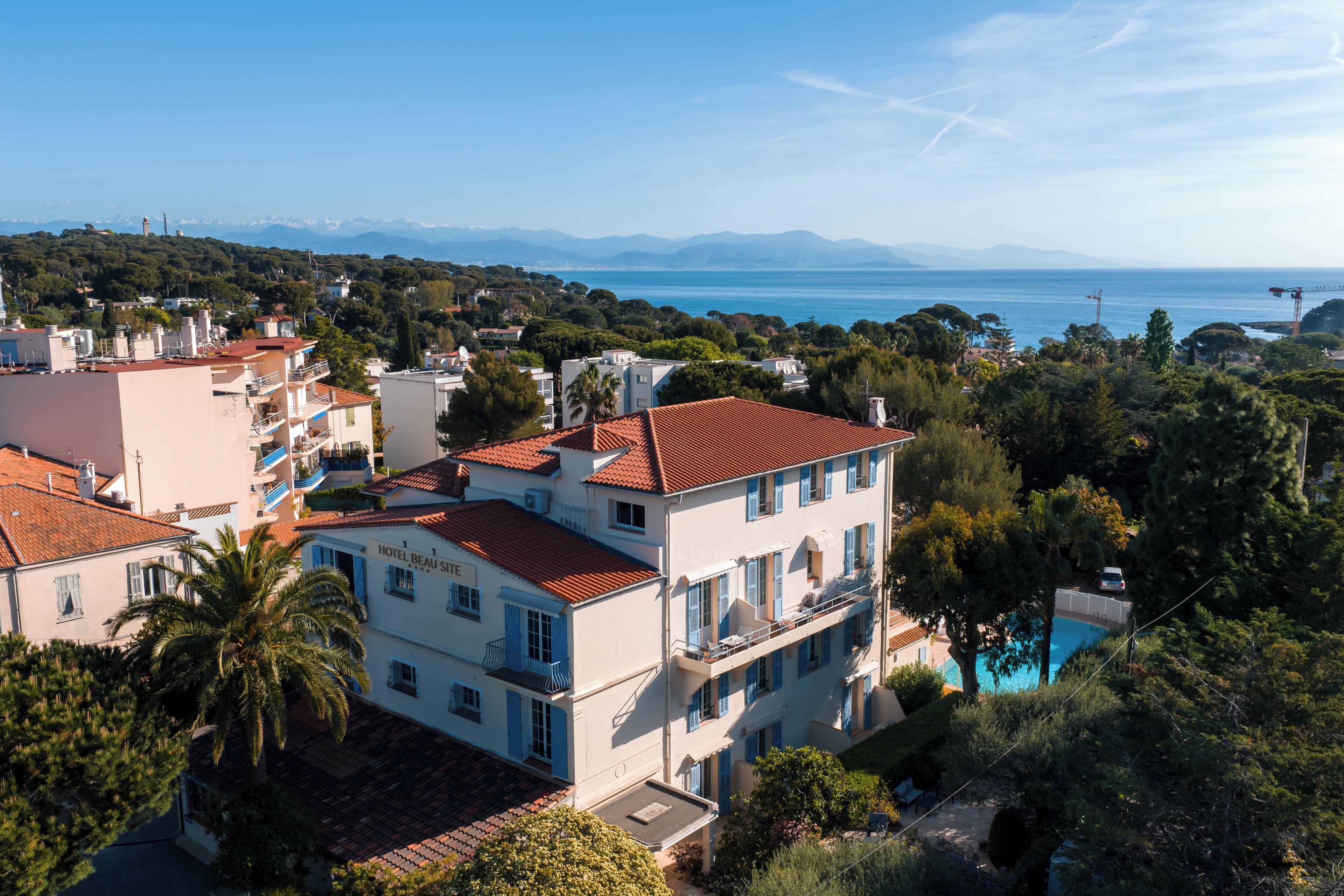 A hotel with multiple floors, balconies, and a swimming pool.